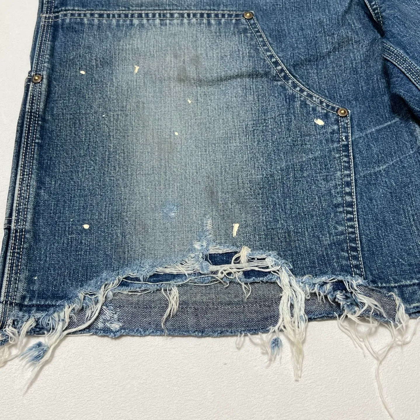 SAINT Mxxxxxx DOUBLE KNEE SHORTS/BLU Knee patches splashed with ink and water-splashed denim shorts. Denim blue S-XL. Custom-woven and dyed denim fabric with clear texture. Heavy-wash water-fading treatment to create local mottled fading/hole effects. Artificial distressing to simulate natural wearing marks. VINTAGE sense. Original consistent damage treatment. Hand-splashed ink and paint. Original consistent wash mark/pocket mark. Double knee patch. Rivet reinforcement. Improve functionality while enhancing design